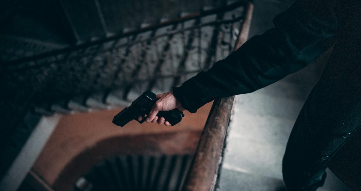 person in black jacket holding black gun